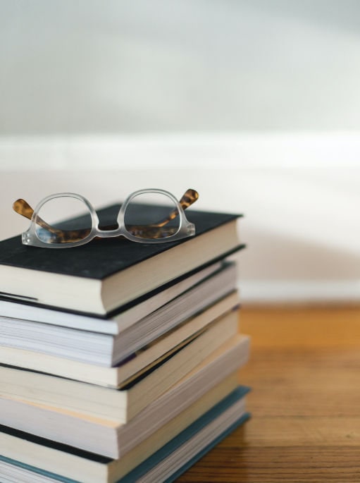 a pair of glasses on a pile of books